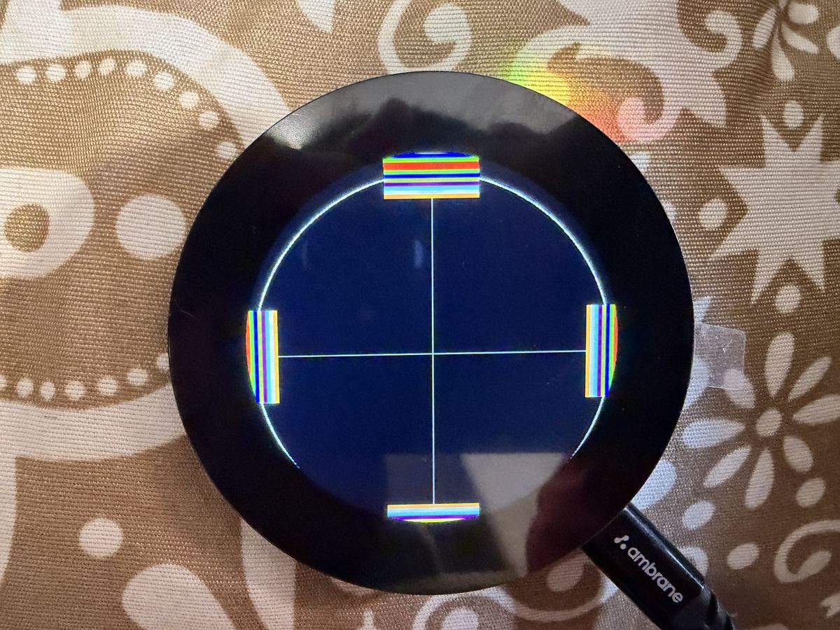 Round screen showing a misaligned test pattern
