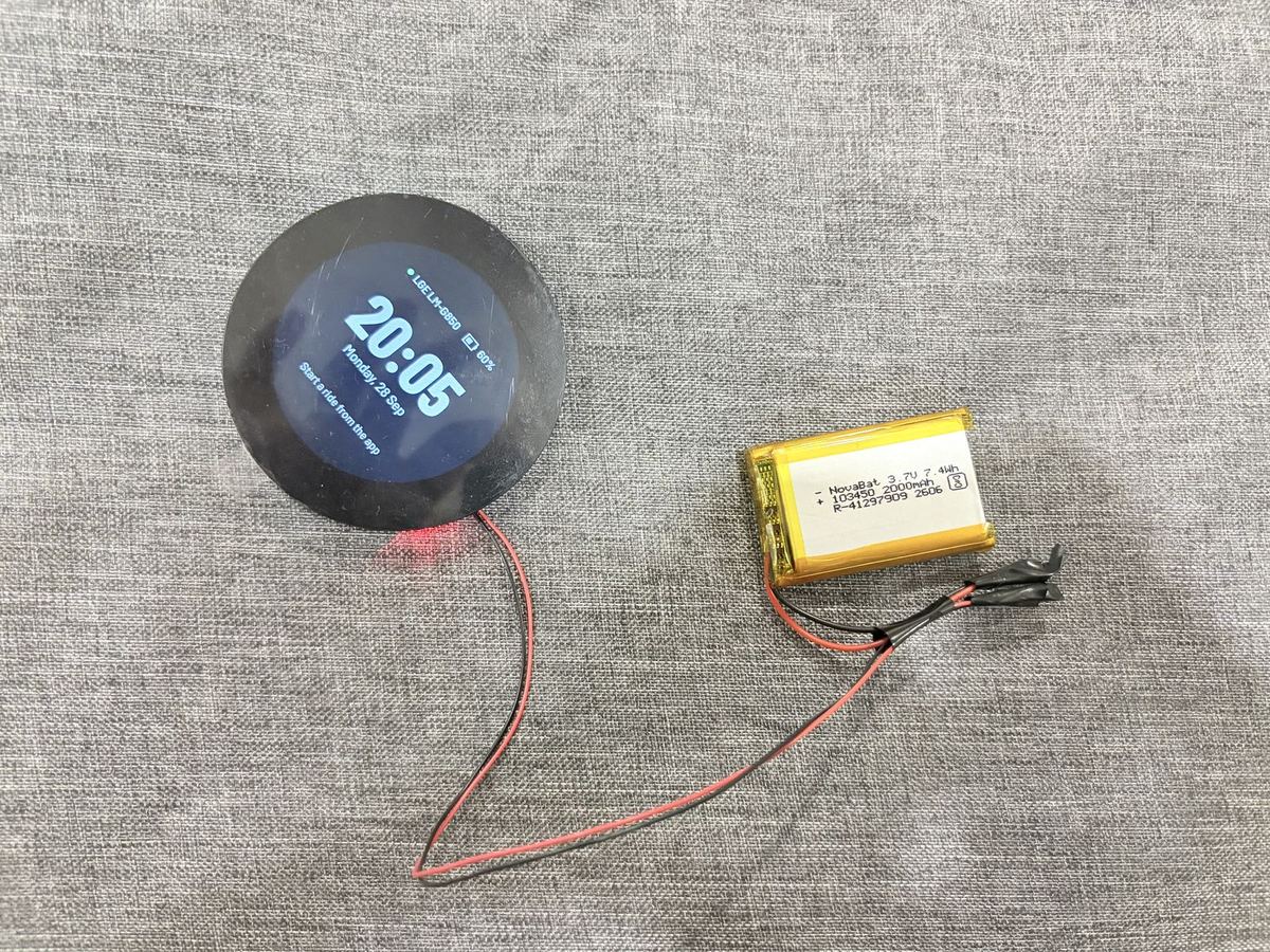 Round screen showing the clock, wired to a bare battery